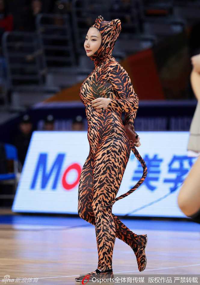 身着红色民族风长裙的啦啦队员在赛场中央翩翩起舞，裙摆随着旋转的舞步飘扬，宛如一朵盛开在球场中央的红玫瑰。