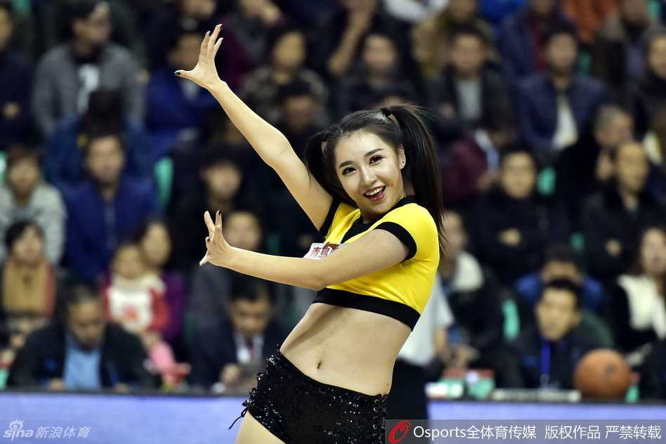 CBA赛场上的美丽风景线 篮球宝贝热舞瞬间点燃冬日激情 身着金色亮片短裙的篮球宝贝在赛场中央激情热舞,马尾辫随动感节奏飞扬,活力四射。