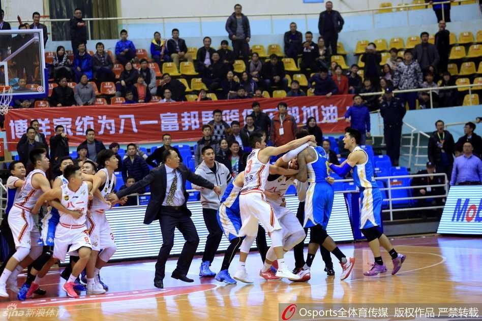 在一片混乱中，福建外援泰勒被多人围住，显得孤立无援，场边的球迷也站起来张望，整个球馆被紧张和混乱的气氛笼罩。