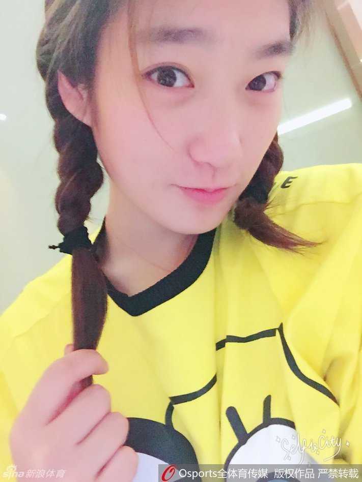 李梦身着简约的白色T恤，乌黑的长发披散在肩，她微微侧身露出甜美的笑容，这一刻她不再是球场上的得分机器，而是一位温柔可爱的时尚少女。