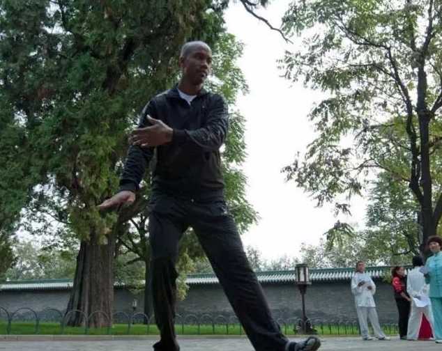 绿树掩映的公园里，这位外国友人正神情专注地打着太极，一招一式间透着一股认真劲儿