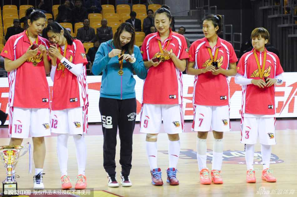 三冠王朝荣耀绽放 山西女篮新主场升起不朽旗帜 教练组成员在聚光灯下接过冠军戒指,脸上洋溢着满足的微笑,并与身边的弟子们分享着这份属于团队的荣誉。