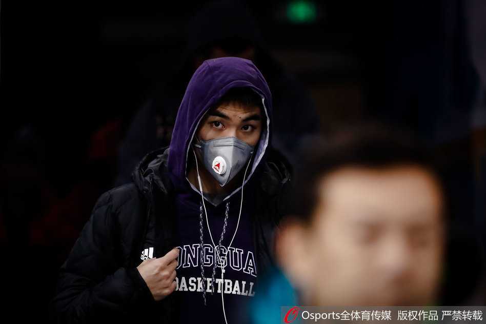 训练馆外，一名深圳队球员口罩遮面低头快走，背景是灰白的天空，仿佛在无声地抗议着恶劣的天气。