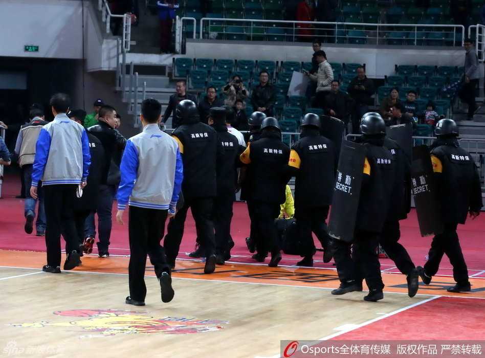 京晋大战硝烟散尽 安保筑起最后防线 数名身穿黑色制服的安保人员紧密环绕,组成一道移动的人墙,将被护送的裁判员紧紧围在中间,他们的神情严肃而警惕,目光扫视着周围涌动的人群。