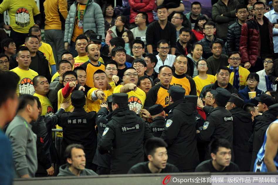 京晋大战硝烟散尽 安保筑起最后防线 混乱的看台通道内,几名安保人员手挽手形成一道警戒线,努力将情绪激动的球迷隔离开来,为身后的裁判组开辟出一条狭窄而艰难的撤离通道。