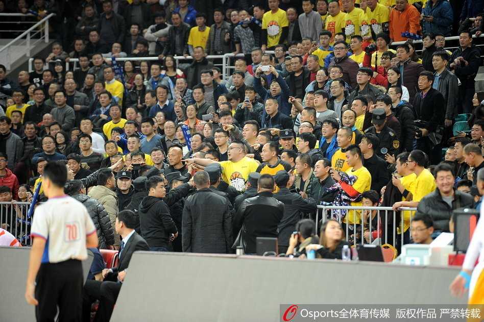 京晋大战硝烟散尽 安保筑起最后防线 看台上的球迷们集体站立,目光齐刷刷地投向场地一角的冲突区域,许多人高举着双臂,面部表情因高声呼喊而变得扭曲,现场气氛紧张到了极点。