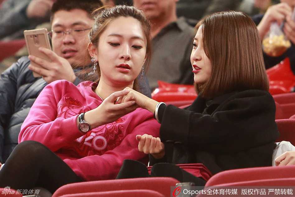 方硕女友与翟晓川女友亲昵相依，两人脸上洋溢着甜美的笑容，仿佛与赛场内的激烈拼抢隔绝，自成一片温馨的小天地。