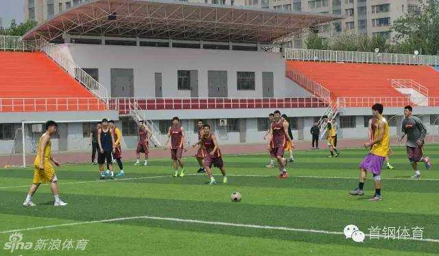 首钢男篮的小伙子们在绿茵场上全神贯注，只见吉喆一个箭步上前，对二队的小将形成了极具压迫感的贴身逼抢，眼神里满是专注。