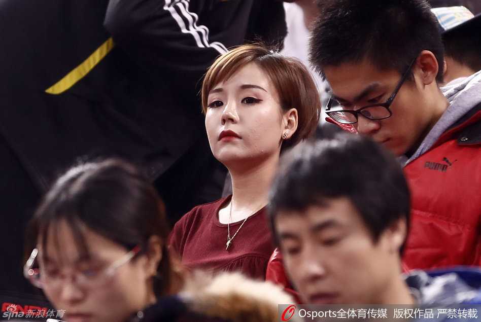 即便周围球迷情绪激动，她依然安静地坐在那里，手举充气棒轻轻靠在唇边，一双会说话的眼睛仿佛看穿了赛场的每一个战术变化。