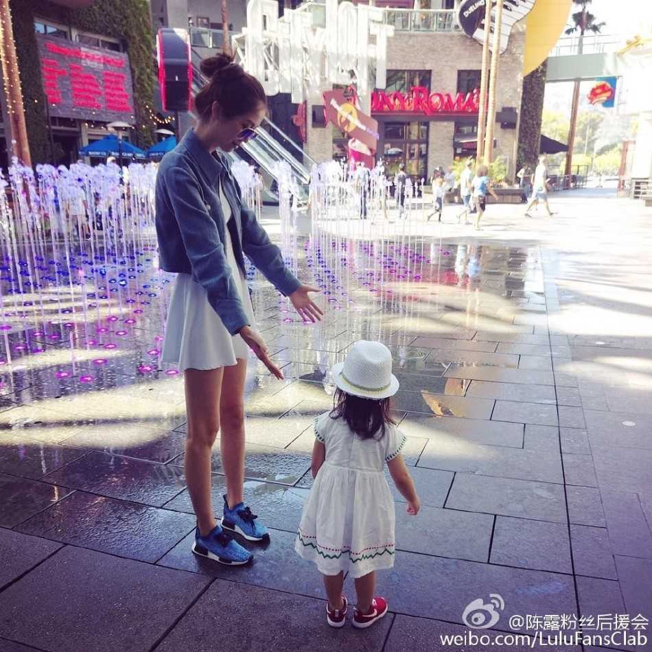 陈露随意倚在墙边，简约的黑色装扮衬得那双美腿愈发白皙夺目，光影在她身上流淌，仿佛在诉说一个关于自信与从容的故事