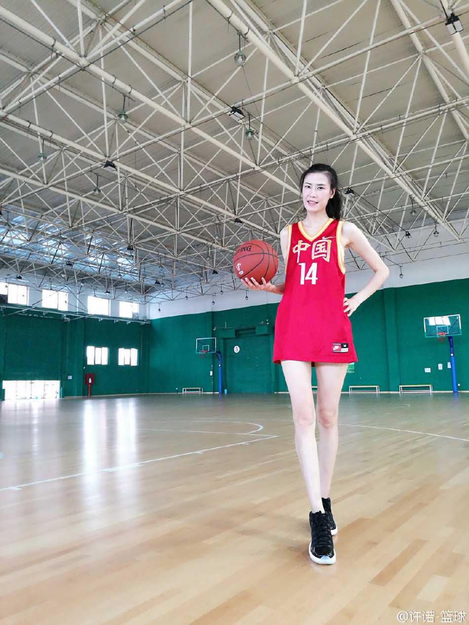 許諾身著時尚的深色連衣裙，依靠在欄杆上，一雙逆天長腿格外矚目，她眺望遠方，臉上洋溢著自信從容的微笑，展現出球場外的獨特時尚魅力。