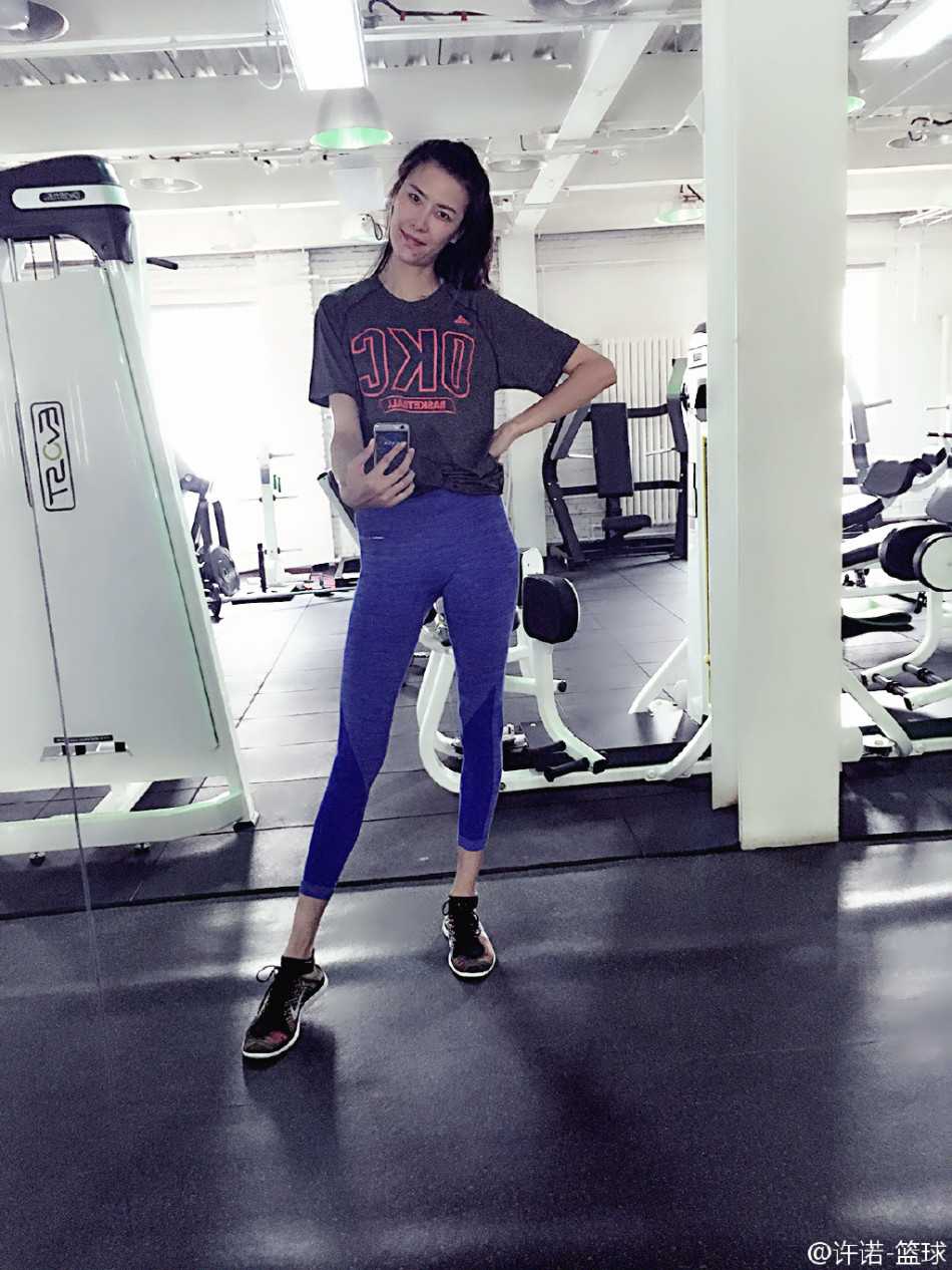 訓練場邊的許諾，將長髮隨意紮起，身穿寬鬆訓練服，正低頭專注地與教練溝通戰術，認真嚴肅的神情凸顯了她對籃球事業一絲不苟的專業態度。