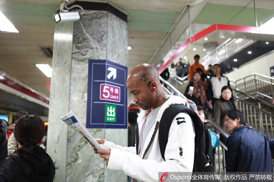 相声剧场里，马布里身穿大褂与相声演员曹云金同台，他手持折扇表情认真，而曹云金则在一旁做出夸张的逗哏表情，台下观众笑声一片