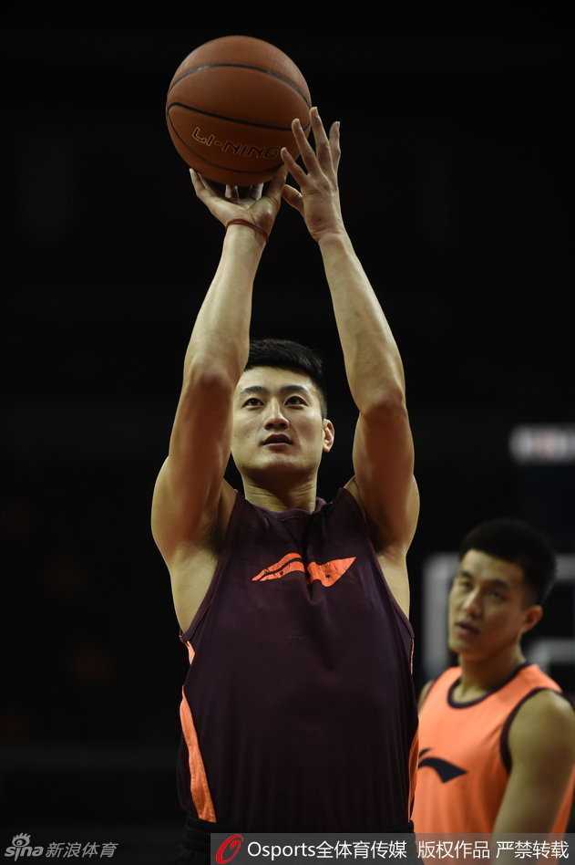 山西队的段江鹏在训练中认真练习投篮，身旁的篮球架下，队友们正在等待下一轮的投篮训练。