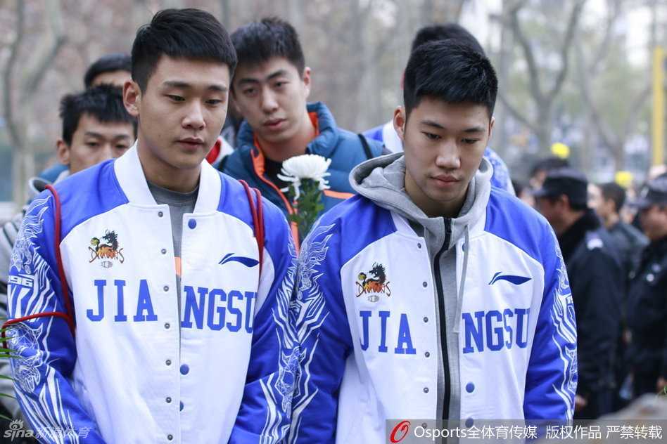 公祭日里的大地哀鸣:江苏肯帝亚将士以肃穆敬祭三十万同胞 队员们排成一列,向着刻满遇难者名字的纪念碑深深鞠躬,身体几乎弯成九十度,背景是苍翠的松柏,寓意着精神不死与和平永驻。