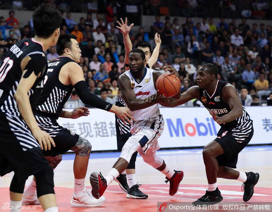 韩德君在广东队多人围堵下，用强壮的身体死死护住篮球，犹如磐石般稳固，等待队友接应。