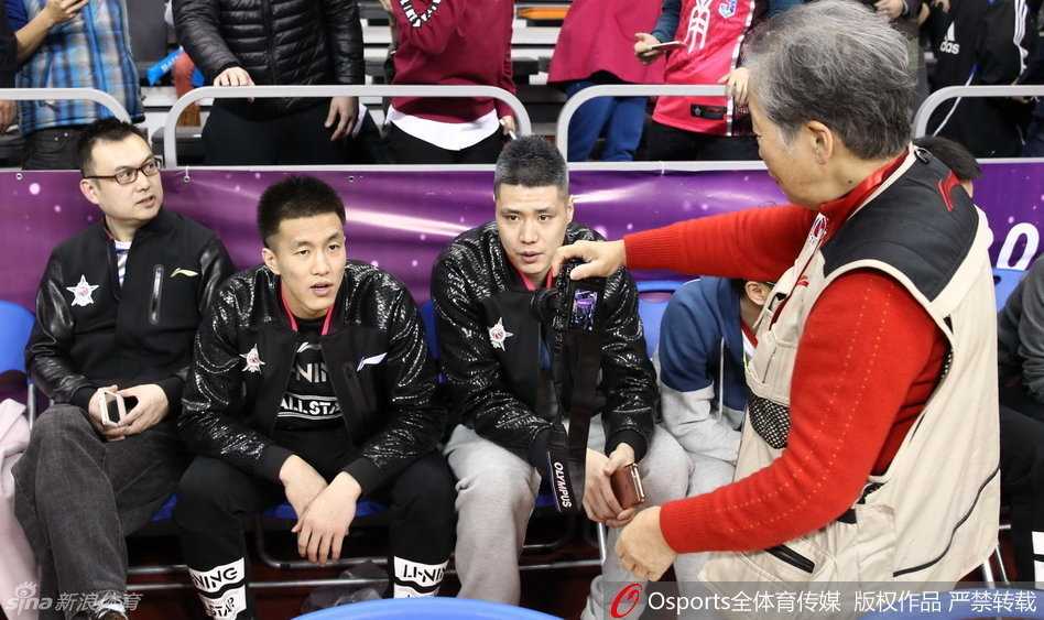 辽宁队的贺天举与郭艾伦在场边神态轻松，二人如同赛场外的哥俩好，脸上带着淡定的微笑，仿佛在聊着与比赛无关的趣事，大侄子标志性的笑容极具感染力。