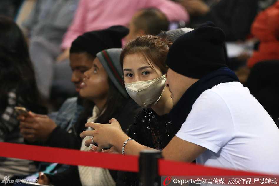口罩遮不住的星芒:孙悦爱妻陈露五棵松观战记 陈露在看台上接听手机,手指纤长,侧脸轮廓在球场灯光下显得格外立体精致。