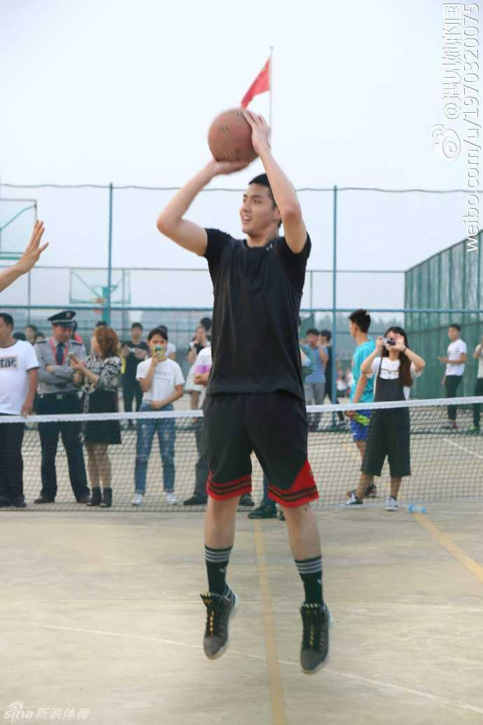 吴亦凡在南京高校球场边侧身而立，目光坚定望向球场，即使隔着围网也难掩其俊朗侧颜与出众气质。