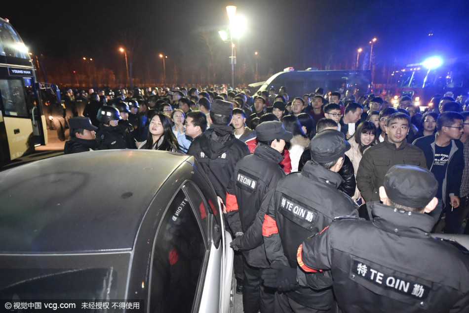 一名戴眼镜的安保人员神情紧绷，他张开双臂，努力拦截着向前涌动的球迷。身后是无数双挥舞的手，身前是亟待维护的赛场底线，他的背影在球迷组成的人潮映衬下，显得孤独却又坚不可摧。