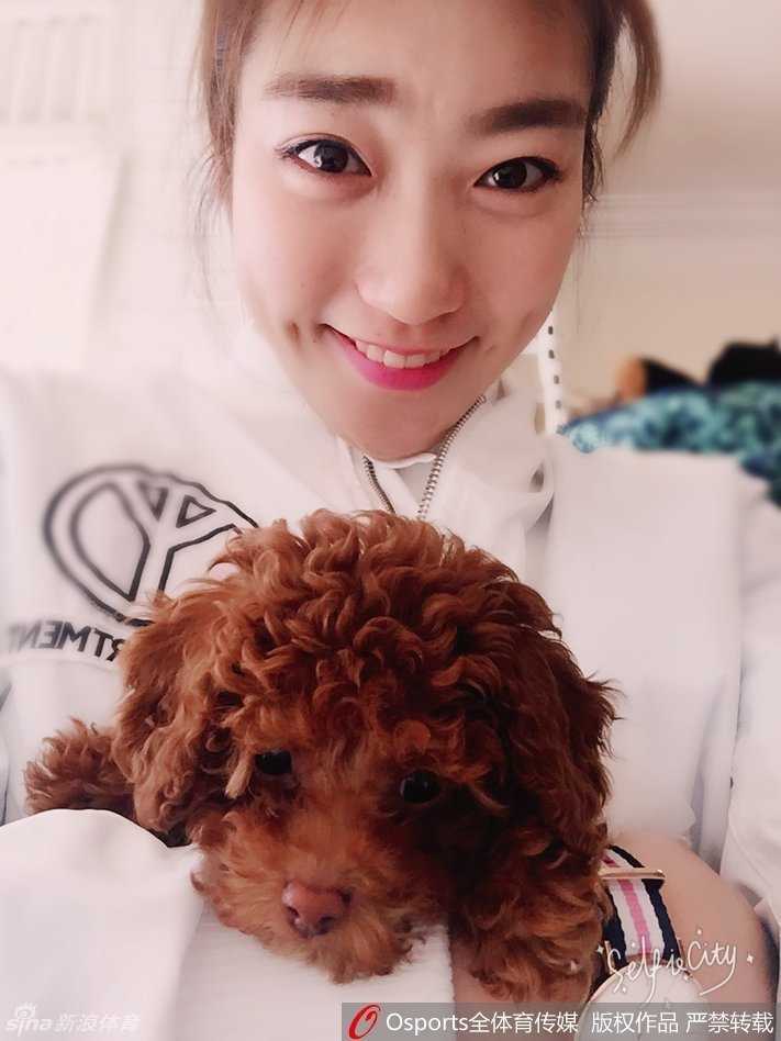 李梦将小泰迪轻轻举起，脸上绽放出明艳动人的自拍笑容，这一刻她不是球场上的明星，只是一个享受生活的阳光女孩