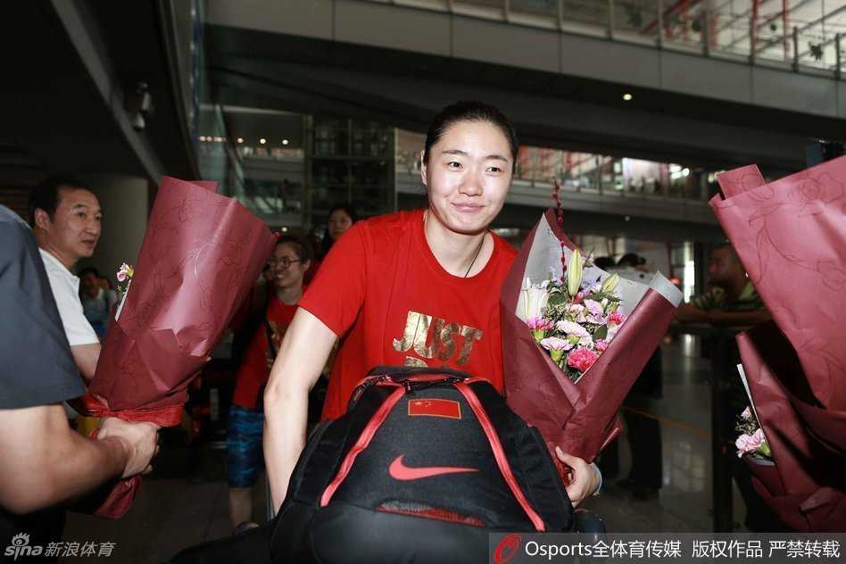 女篮姑娘们身着统一红色领奖服，在首都机场留下一张珍贵的大合影，每个人脸上都洋溢着胜利的喜悦和对奥运的向往。