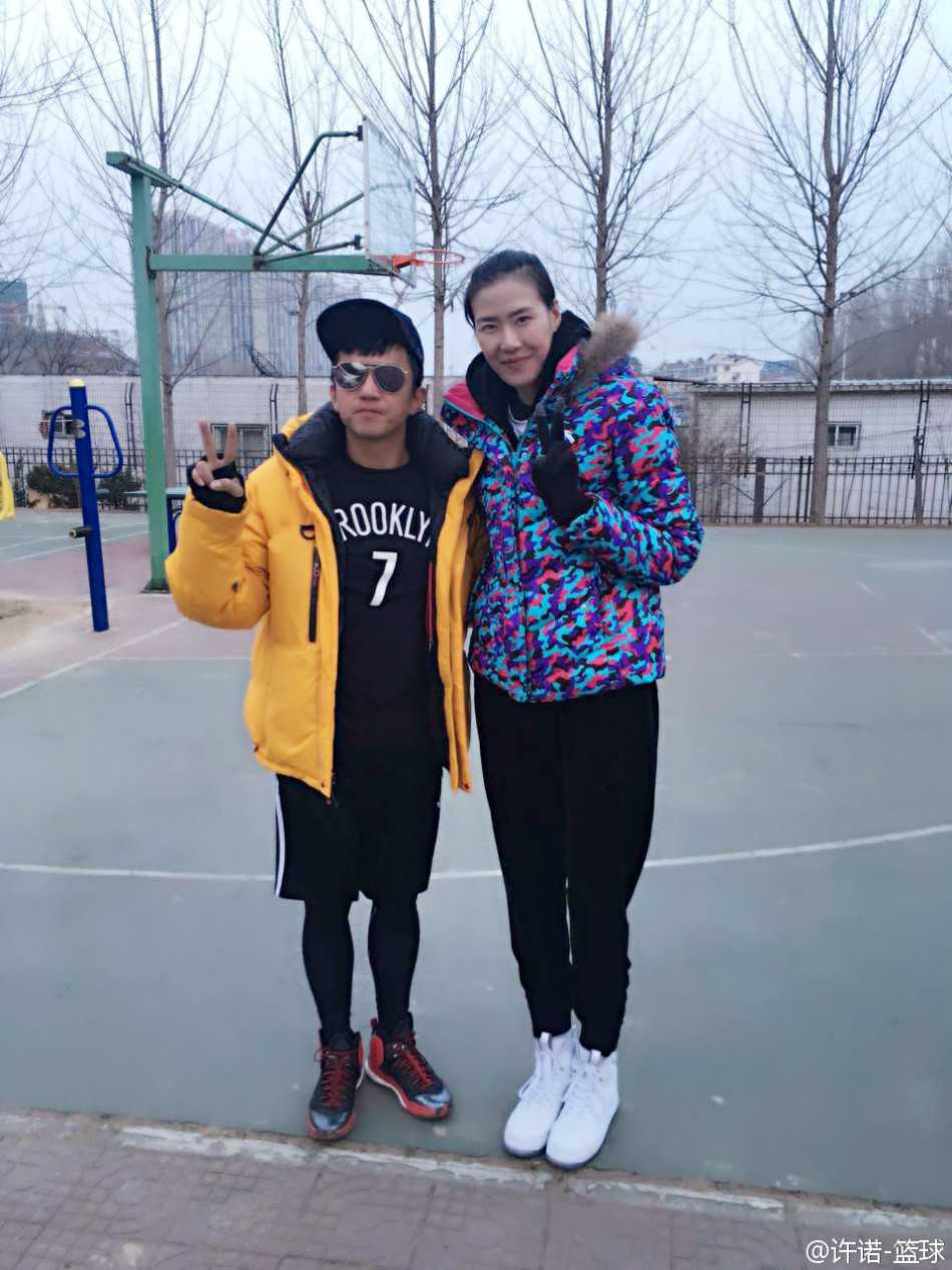 许诺与著名编剧俞白眉在场上愉快合影，两人笑容灿烂，身后是喧闹的球场，展现了体育竞技之外的轻松与友谊。