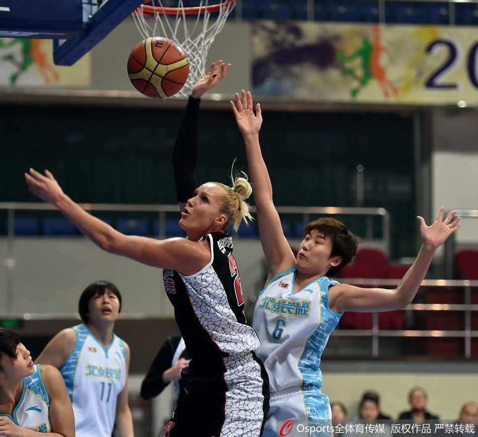 北京女篮外援福尔斯在广东队内线群中高高跃起，单手将球砸入篮筐，身后是广东球员无奈的神情。