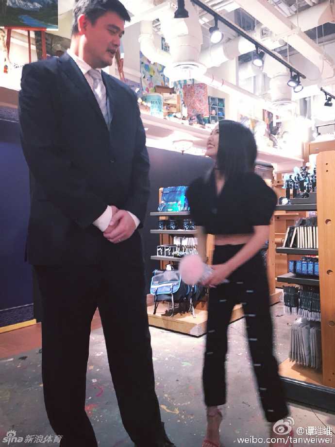 李克勤在姚明身边双手点赞，两人的身高差像P图效果，姚明表情亲和风趣