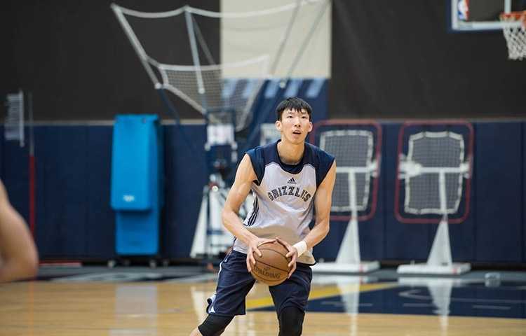 周琦身披灰熊队训练服，在场上进行拉伸准备，眼神坚毅地望向前方，仿佛在积蓄着即将爆发的能量。