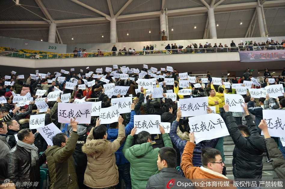 镜头拉近，一位戴着眼镜的年轻男球迷双手高高举起一张A4纸，上面用黑色记号笔手写着“还我公平”四个大字，这四个字虽然简陋，却力透纸背，喊出了全场球迷的心声。