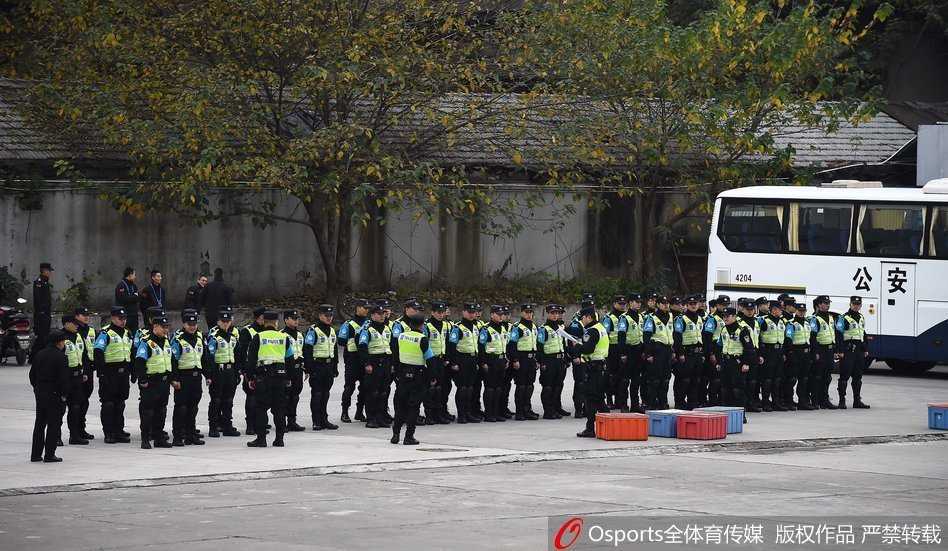 夜幕低垂，执勤民警依然坚守在户外的岗位上，身后是灯火通明的体育馆，身前是川流不息的球迷人群，他们用背影守护着赛场的安宁。