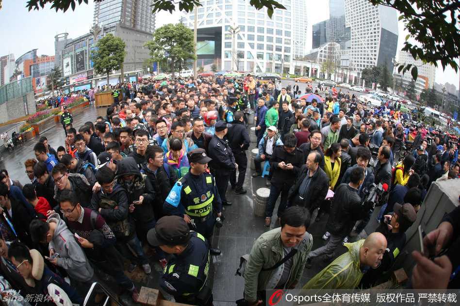 狂热球迷们在四川省体育馆外蜿蜒数百米，冒雨排队等待购票，人群中各色雨伞如花朵般绽放，构成了春日蓉城一道独特的风景线。