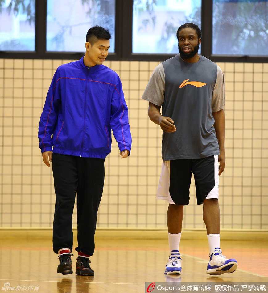 迪奥古与王仕鹏进行战术沟通，王仕鹏面带自信笑容，比划着新的跑动路线