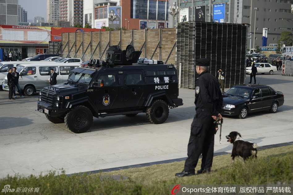 总决赛战前风云:警犬特警齐上阵,安保防线铸就钢铁赛场 严阵以待的安保人员排成一列,背对赛场,面向观众,他们的背影如同坚实的屏障,守护着场内的欢呼与激情。