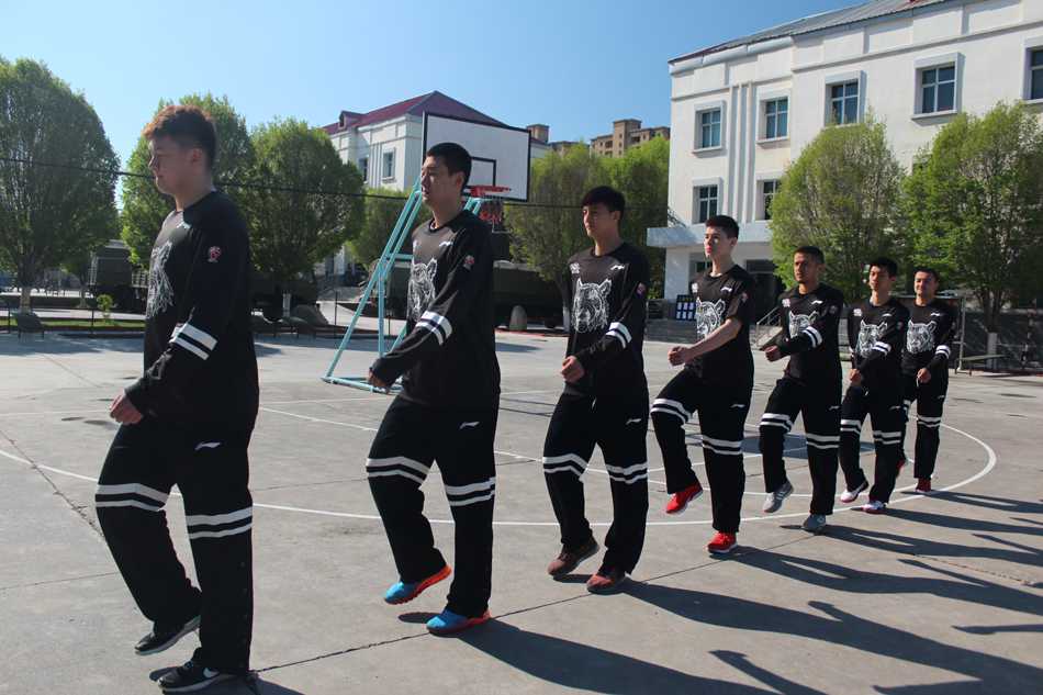 训练场上，新疆球员们正在进行队列会操，他们神情专注，步伐稳健。远处，主教练李秋平背负双手，静静观察着弟子们的一举一动，仿佛在审视一支即将踏上战场的军队。