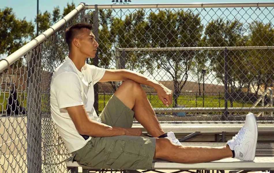 在柔和的暖色调光线中，易建联侧身回眸，脸上带着浅浅的温暖笑意，瞬间拉近了与观众的距离，显得亲和力十足。