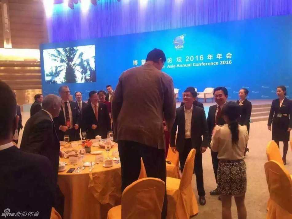 马云仰头微笑望向姚明，眼神里满是惊喜与调侃，仿佛在说‘你小子又长个了？’