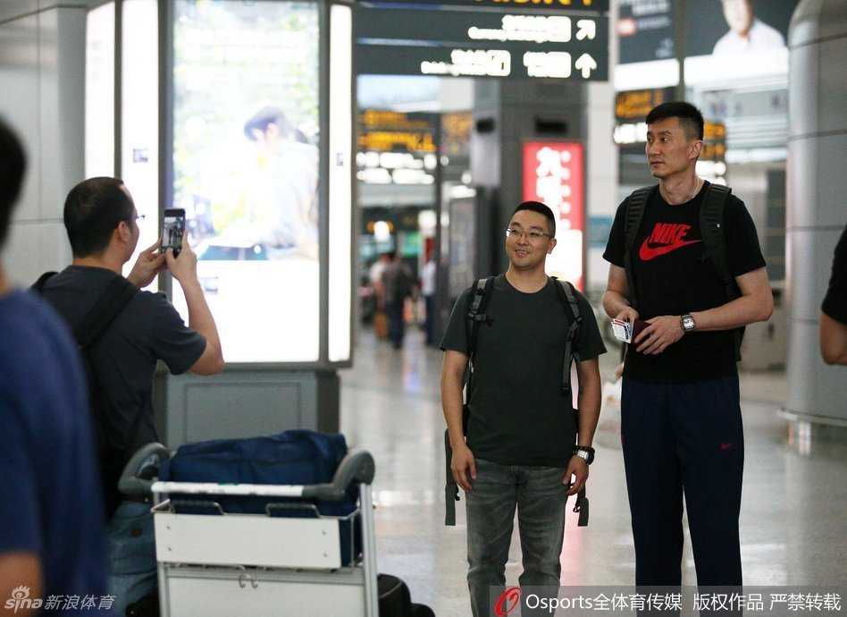 主教练杜锋与麾下两员小将高尚、董瀚麟在机场角落热聊，杜锋表情严肃似乎在叮嘱着什么，两人认真聆听，周围是熙攘的旅客，仿佛预示着老大哥正在传授新赛季的制胜秘诀。