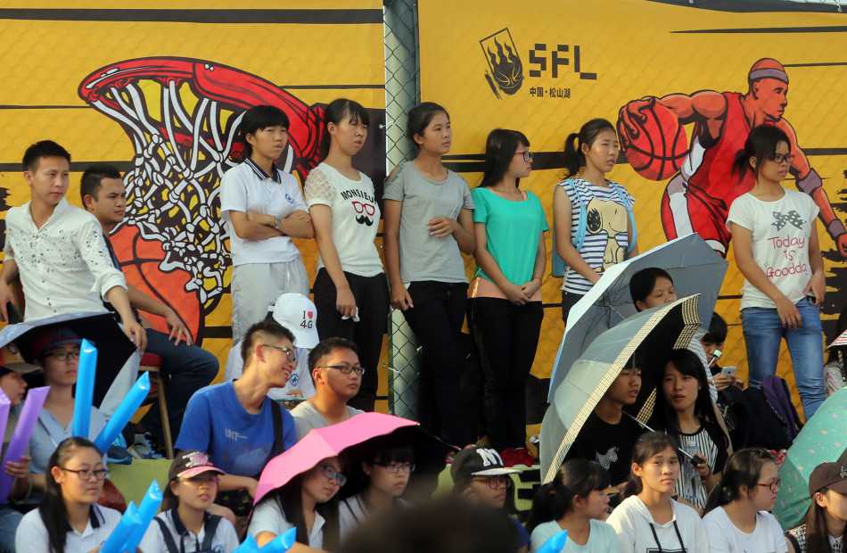 松湖造梦街头篮球盛宴激情上演 场边的观众席座无虚席,几位美女球迷也被激烈的比赛吸引,目不转睛地关注着场上局势。