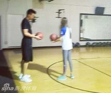 在健身房放松区，丈夫安静地坐在一旁等待正在拉伸的妻子，画面温馨宁静