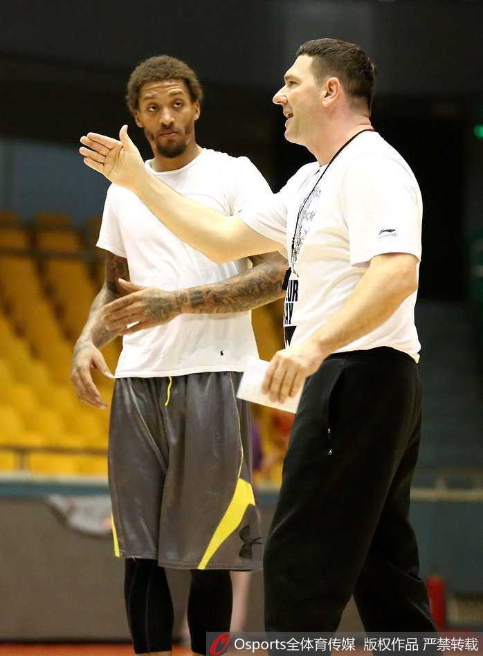 泉城蓄力,纹身下的专注:山东男篮新季起航 训练间隙,比斯利用毛巾擦着汗,微笑着与身边的队友杰特交谈,两人似乎在交流着刚才某个回合的配合心得,气氛融洽。
