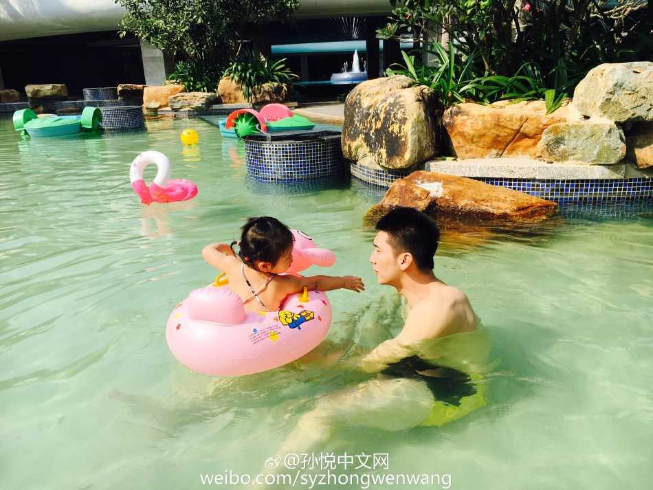 泳池里的超级英雄:孙悦与“小月亮”的温馨父女时光 孙悦搞怪地将头探入女儿的小游泳圈中,假装成顽皮劫匪,手持水枪准备喷射