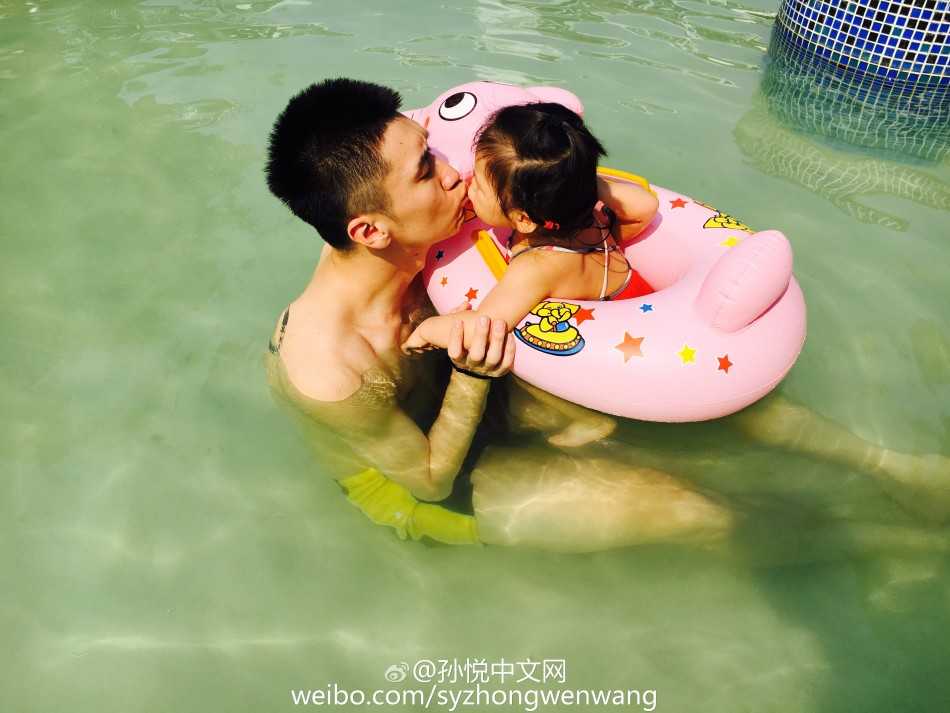 泳池里的超级英雄:孙悦与“小月亮”的温馨父女时光 孙悦温柔亲吻女儿小月亮脸颊,小月亮坐在泳池边,父女二人亲昵互动画面甜度爆表