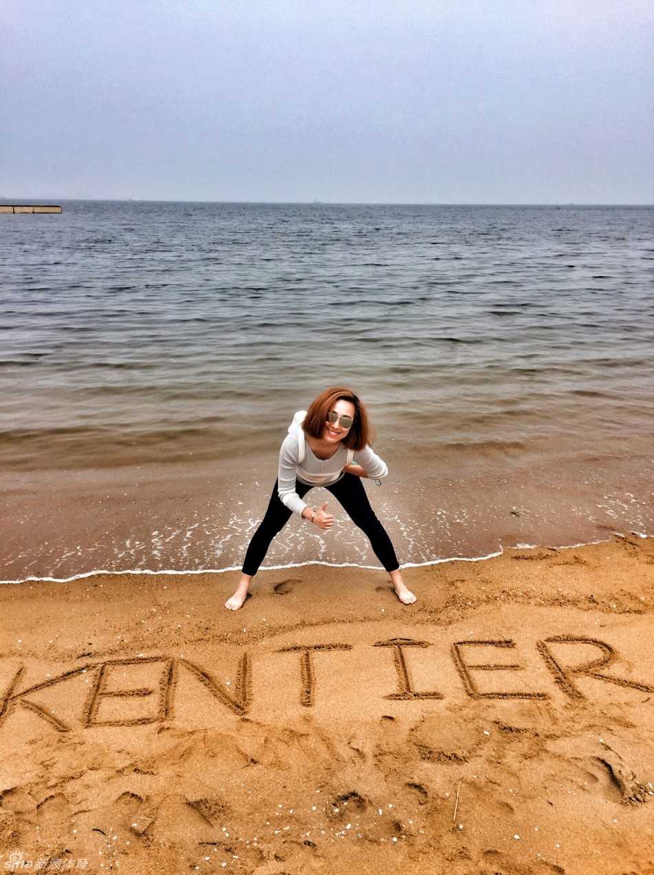 在拥挤的人群中，一位球员正半蹲着身子，耐心地为一位坐在轮椅上的老球迷在纪念品上签名，旁边的人纷纷投来赞许的目光。