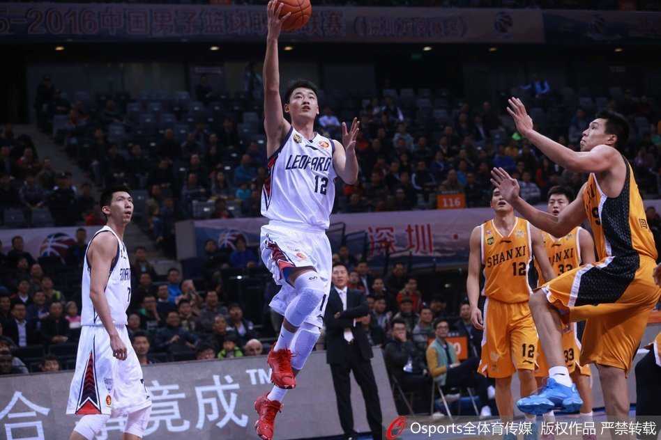 深圳队李慕豪在山西队内线群中高高跃起，以一记势大力沉的单手劈扣终结进攻。