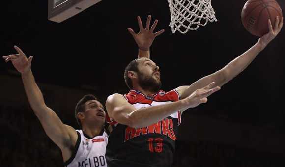 澳洲NBL战报:墨尔本加时惜败,珀斯险胜阿德莱德,新西兰破坏者双杀对手 场边教练神情严肃地给队员布置战术,球员们围成一圈认真聆听,身后是热情的主场球迷