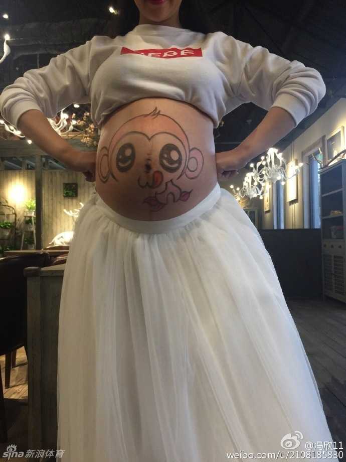 冯欣与爱妻甜蜜依偎，两人双手交叠轻放在彩绘孕肚上，仿佛在绘制一幅名为“未来”的美好画卷，幸福感油然而生。