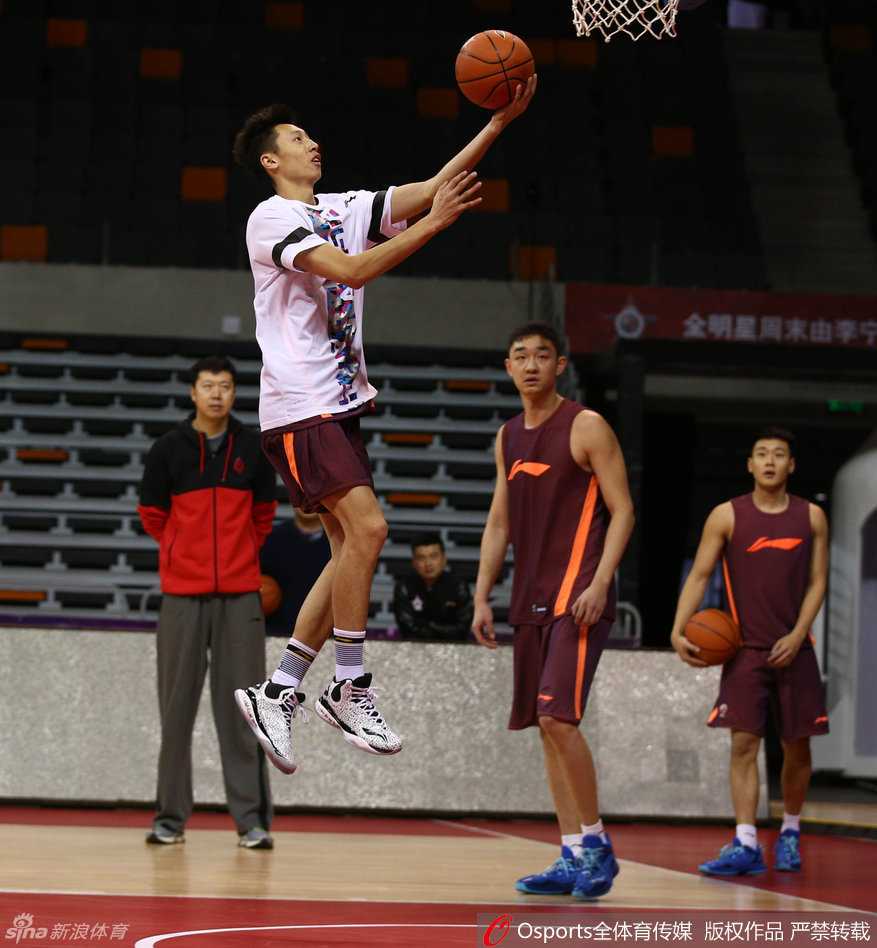 王治郅手把手指导胡金秋篮下技术，他用自己的身体挡住防守人，右手高高举起示意传球路线，胡金秋在身后认真模仿着每一个细节。