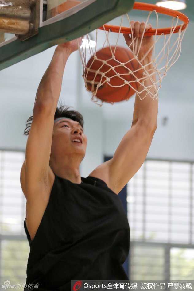 训练场上王哲林高高跃起接球，身体舒展成一张弓，在对手封盖前一秒稳稳将球投出，眼神专注地凝视着飞向篮筐的篮球。
